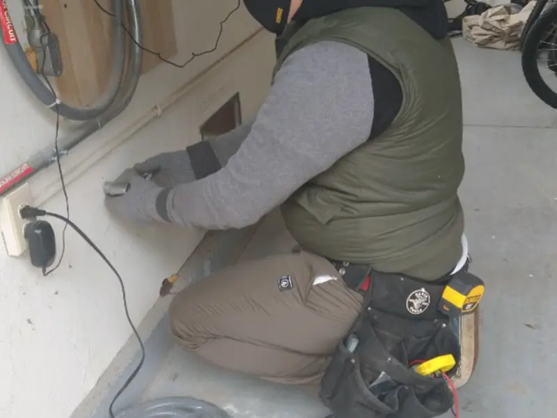 Electrician performing outlet wiring in a Florida Ridge garage